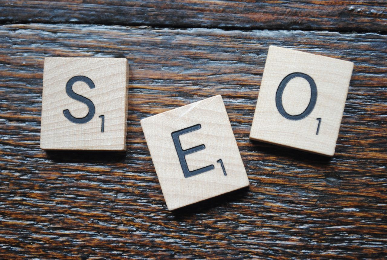 Crafting Captivating Headlines: Your awesome post title goes here Close-up of Scrabble tiles spelling SEO on a wooden table for content strategy.