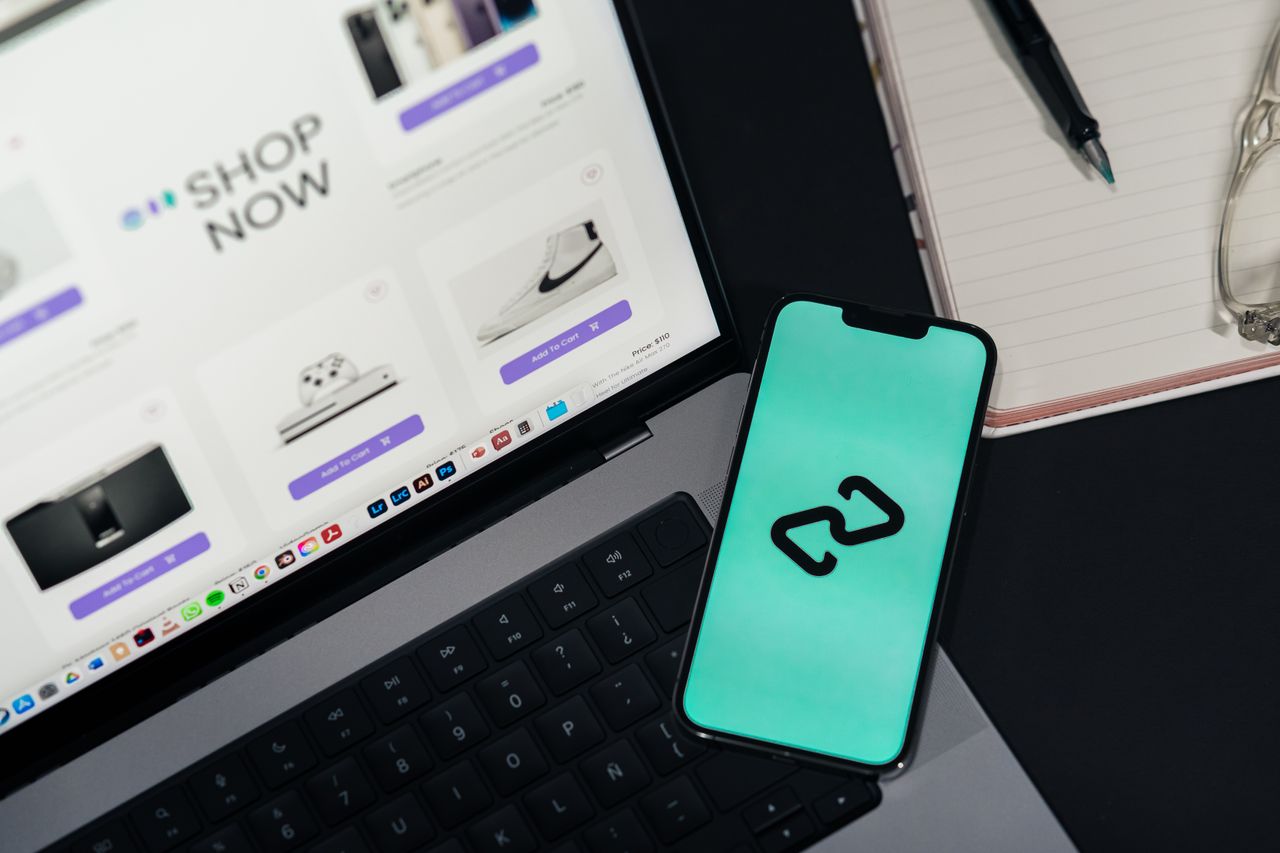Home A smartphone and laptop displaying online shopping platforms, suggesting digital retail.